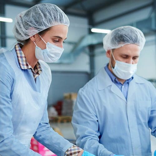 a group of people wearing surgical masks and hair nets